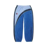 Pantalon de jogging Supreme x Umbro confeccionado en tejido de velour, de diseño colorblock en tonos azul, celeste y negro. Cuenta con cintura elastizada, puños en los tobillos, bandas laterales con ribetes y bordados de las marcas junto a un escudo en el frente.