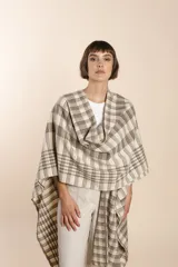 Ruana de lana fina color crudo con terminación envivada.