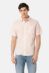 Camisa manga corta color rosa claro, con cuello clásico, cierre frontal con botones y bolsillo en el pecho.