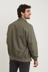 Campera estilo bomber color verde oscuro, con cierre metálico, dos bolsillos externos con cierre y un bolsillo interno.