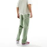 Pantalón cargo verde de corte holgado, con bolsillos laterales y logo de Nike bordado en la pierna izquierda.