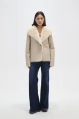 Chaqueta de eco-cuero negro con interior y cuello de piel sintética, diseño holgado, manga larga y cierre frontal con un botón.
