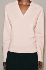 Sudadera de algodón en color rosado, con escote en V y mangas largas de corte holgado.