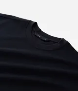 Remera masculina de corte boxy, color marrón oscuro, con cuello redondo y mangas cortas. Confeccionada en malla pesada con textura gomosa.