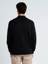 Campera de punto tipo sweater con cierre frontal completo, cuello alto y detalles en color gris en el borde del cuello, puños y ruedo.