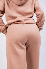 Pantalón de jogging gris oscuro, de corte holgado con cintura elástica y puños ajustados en los tobillos. Presenta bolsillos laterales y un pequeño logo bordado en la pierna izquierda.