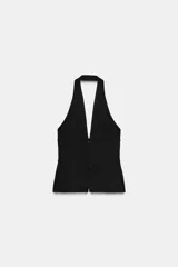 Top entallado color negro de cuello halter, con escote en V pronunciado, espalda descubierta y cierre frontal con ganchos metálicos.