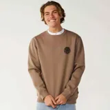 Buzo de cuello redondo color marrón claro, con pequeño estampado circular en el pecho con el logo de la marca.