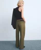 Pantalón tipo jeans de corte recto y tiro medio, color verde militar, con cierre frontal de botón y cremallera, y bolsillos clásicos.