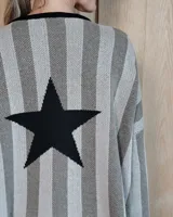 Buzo de punto con diseño de rayas verticales en tonos tostado y beige, con una estrella grande en la espalda y terminaciones en color verde oliva. Presenta un corte holgado y mangas anchas.