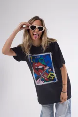 Remera negra de corte holgado con estampado rectangular de estilo pop art con labios, guitarra y letras.