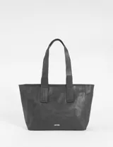 Cartera tipo shopper de cuero vegano en color marrón con acabado efecto gastado. Presenta un diseño amplio y flexible, ideal para uso diario.