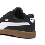 Championes Puma modelo 9-T, de diseño urbano con capellada en color negro, franja lateral característica en blanco y suela de goma color caramelo.