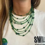 Collar de múltiples hilos color verde con cuentas de tubo y piedras irregulares.