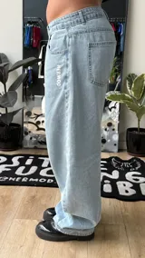 Pantalón de jean estilo baggy, color celeste claro, de tiro alto y corte amplio con detalles bordados en los bolsillos.