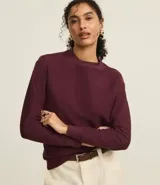 Sweater color borgoña de algodón con poliéster, cuello redondo y mangas largas con puños acanalados.