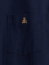 Camisa de corte clásico confeccionada en tejido Oxford, color verde oliva. Presenta cuello abotonado, cierre frontal con botones, mangas largas con puños abotonados y un bolsillo en el pecho con el logo del oso Brannan bordado.