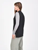 Chaleco de tejido de punto color gris claro, sin mangas, con escote en V profundo y cuello acanalado.