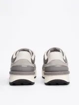 Zapatillas Tommy Jeans grises de corte bajo, con exterior de ante y malla, detalles distintivos de la marca, suela de goma dentada y cierre con cordones.