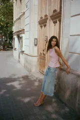 Top rosado de escote recto con tirantes finos que se anudan en la parte superior. Presenta costuras que realzan la figura y cierre con cremallera oculta en la costura lateral.