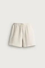 Bermuda relaxed fit color beige confeccionada en tejido de algodón con interior de rizo. Cuenta con cintura elástica con cordón de ajuste y bolsillos laterales.
