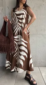 Vestido largo marrón con estampado de hojas blancas, sin mangas y corte holgado.