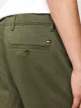 Pantalón chino de corte recto confeccionado en satén de algodón elástico. Presenta cierre de cremallera con botón, bolsillos laterales ribeteados y bolsillos traseros de ojal con botón.