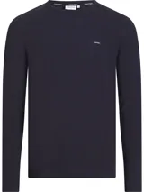 Remera azul marino de manga larga con cuello redondo y corte slim. Tiene un parche con el logo de Calvin Klein en el pecho.