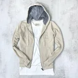 Campera beige de algodón de punto, con capucha forrada y cierre frontal.