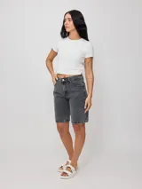 Bermuda de jean azul oscuro, corte recto y largo hasta la rodilla. Confeccionada en denim 100% algodón, con bolsillos delanteros y traseros.