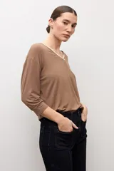 Remera color marrón topo de manga tres cuartos, con escote en V y detalle de ribete blanco en el cuello.