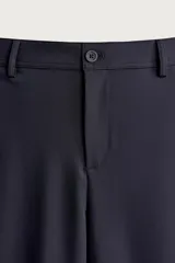 Pantalón regular fit de hombre color negro, confeccionado en tejido técnico ligero con cintura elástica, bolsillos frontales, bolsillos traseros de vivo y cierre frontal con cremallera y botón.