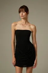 Vestido corto negro con apliques de strass, diseño ajustado al cuerpo, escote strapless y detalle drapeado en la parte frontal.