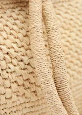 Bolso tipo tote de paja trenzada color beige, con doble asa superior de hombro.
