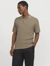 Polo de punto estructurado color greige, con cuello clásico, cierre frontal de dos botones y mangas cortas con terminación acanalada.