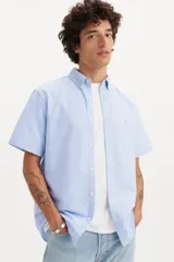 Camisa celeste de manga corta con cuello abotonado y logo bordado en el pecho.