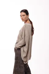 Sweater de punto con silueta amplia y relajada, cuello redondo y mangas largas con puños ajustados. Presenta un diseño de caída fluida y tejido suave.