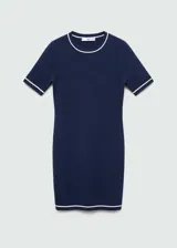 Vestido corto de punto fino, color azul marino, con diseño entallado, cuello redondo y mangas cortas. Presenta detalles de líneas blancas en contraste en el cuello, los puños y el ruedo.