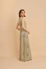 Vestido largo sin mangas de corte recto, con escote en V y breteles anchos. Confeccionado en tejido con encaje y ricamente bordado con canutillos y lentejuelas en tonos dorados y plateados.