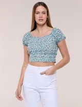 Top corto estampado con diseño floral en tonos azules y verdes sobre fondo blanco, con escote corazón fruncido con elástico, mangas cortas abullonadas y pretina ancha bajo el busto.