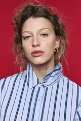 Camisa de algodón celeste con rayas verticales azul marino y marrón, cuello camisero clásico y cierre frontal de botones nacarados.