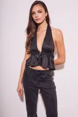 Top negro con escote halter, espalda descubierta y volados en el ruedo.