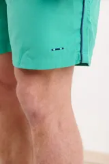 Short de baño verde con cintura elástica y cordón ajustable.