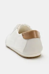 Zapatilla deportiva estilo blucher con pespuntes decorativos en el cuerpo, detalle de talonera en contraste de material y color, cierre mediante cordones y punta redonda.