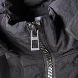 Campera larga tipo puffer color negro, con diseño acolchado, cierre frontal completo, cuello alto y capucha desmontable.