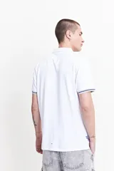 Remera polo color salmón de estilo jersey, corte regular, con logo estampado y detalles en azul marino en cuello y mangas. Confeccionada en algodón y spandex.