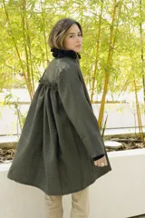 Tapado a cuadros color verde con cuello negro con volados y mangas largas.