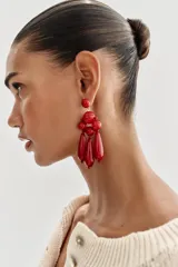 Pendientes colgantes de diseño estructurado en color rojo, compuestos por esferas de distintos tamaños y piezas alargadas en forma de gota que cuelgan en la parte inferior.