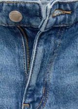 Jeans tiro medio de corte recto en tono azul clásico, con trabillas, cierre delantero de cremallera y botón, y aberturas en el bajo.