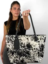 Cartera tipo tote de cuero genuino color marrón oscuro con textura de reptil. Cuenta con doble asa de hombro, cierre superior y un dije colgante de cuero a tono.